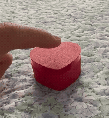 Real printed heart clicker being pressed, in a short looping demonstration