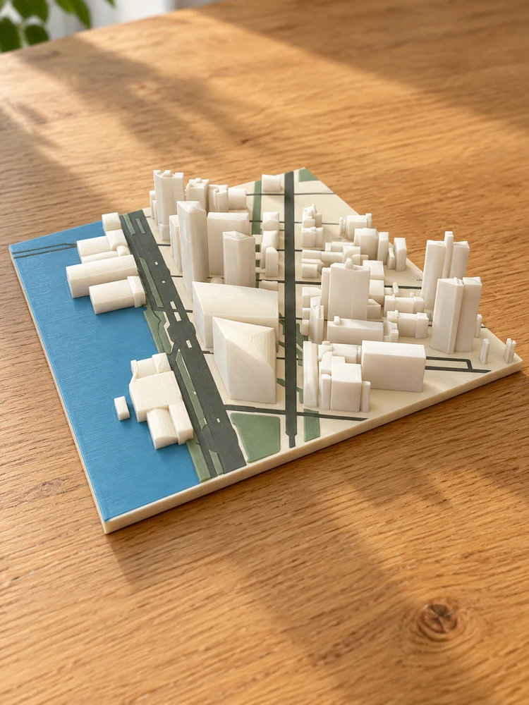 AI visualization of the matching multicolor printed waterfront city model on an oak table